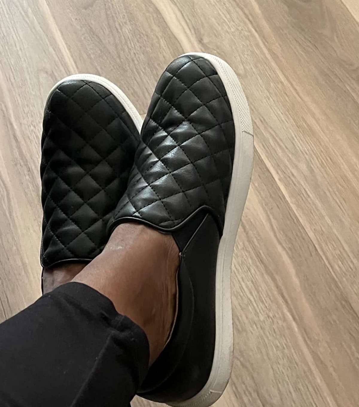 Reviewer wearing quilted black sneakers