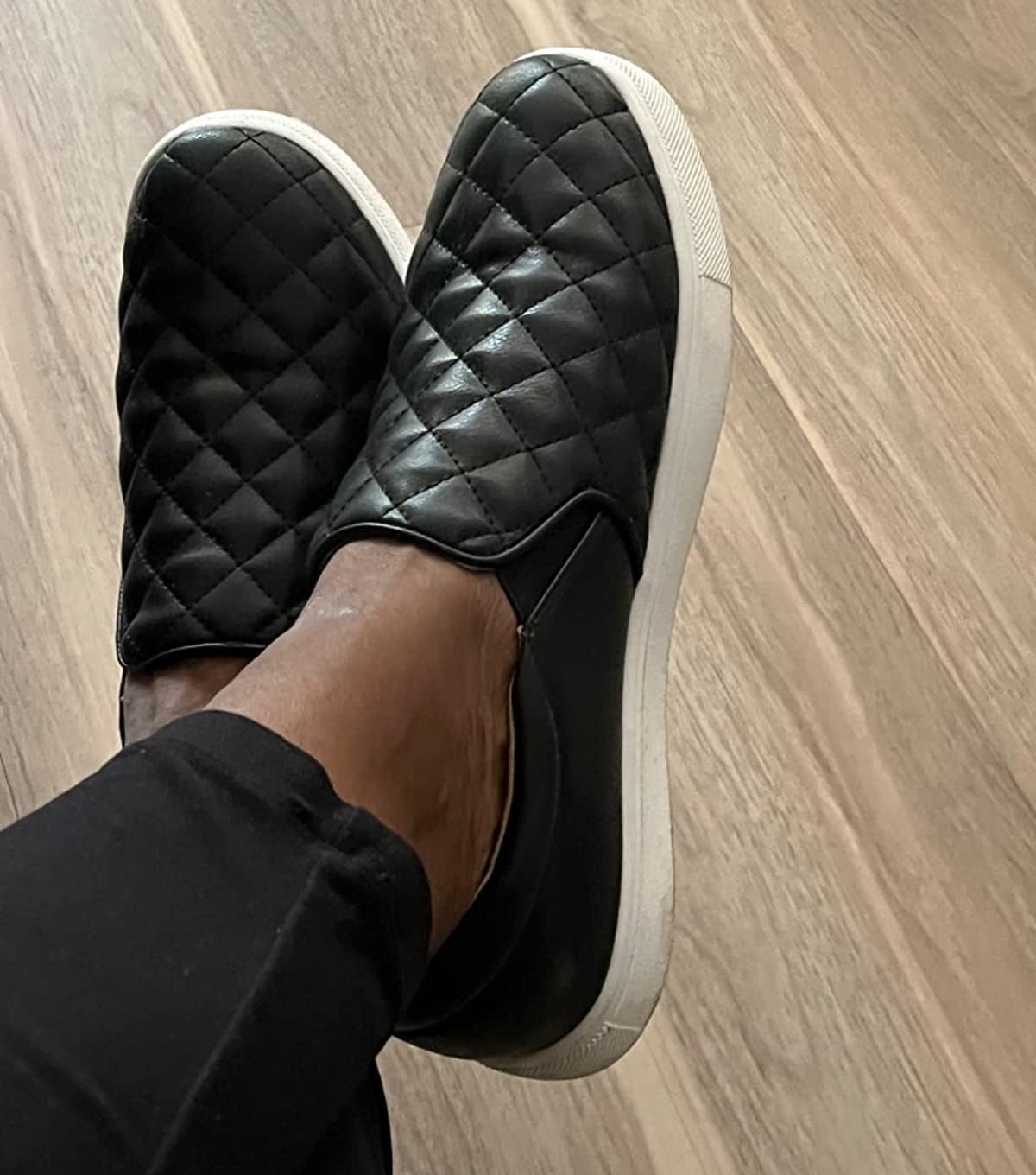 Reviewer wearing quilted black sneakers