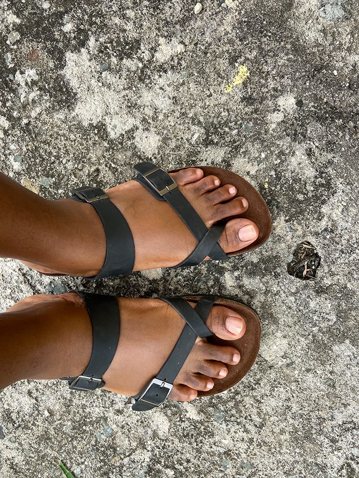 Reviewer wearing black leather cross band footbed sandal