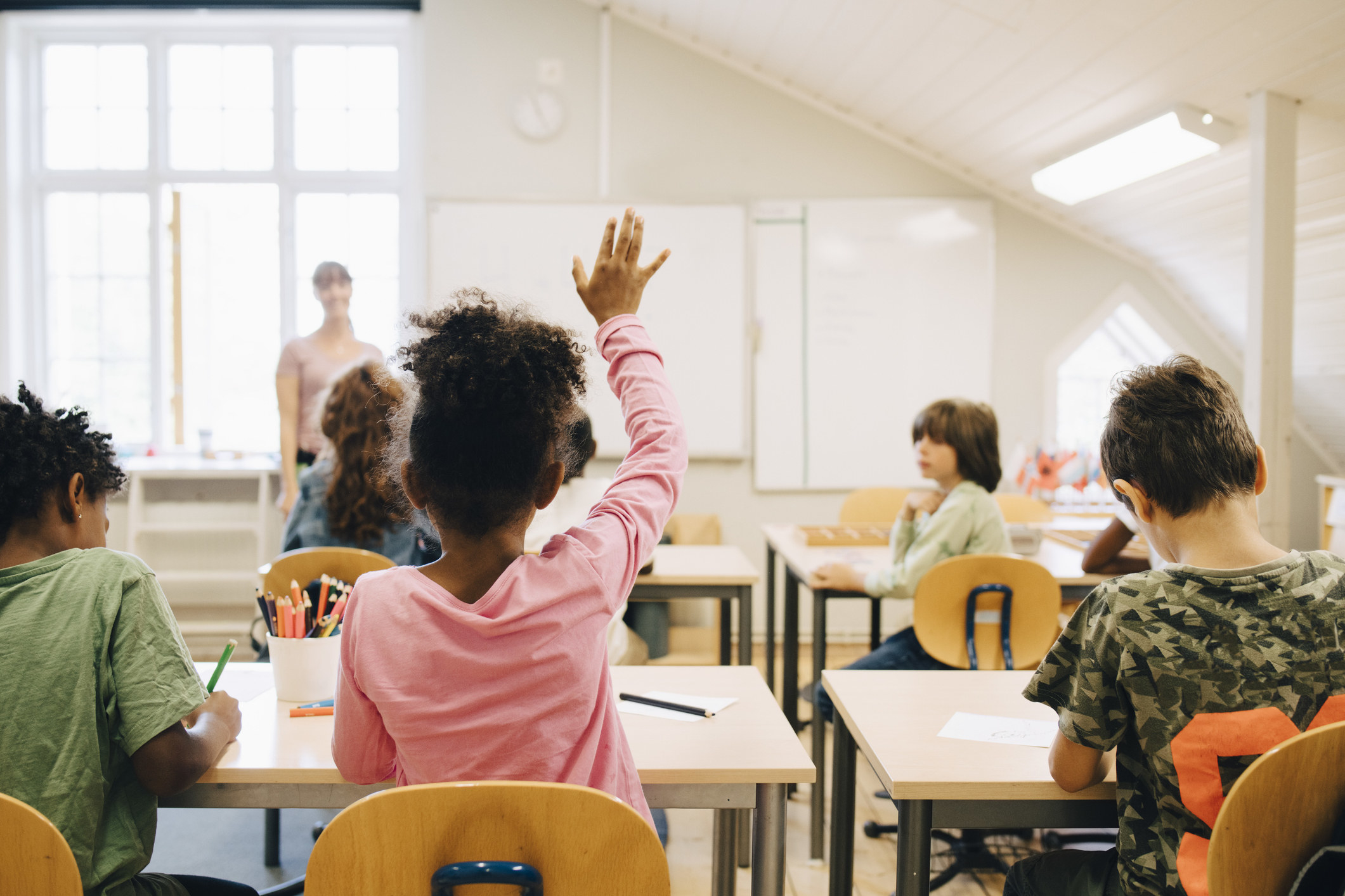 A girl raising her hand in school