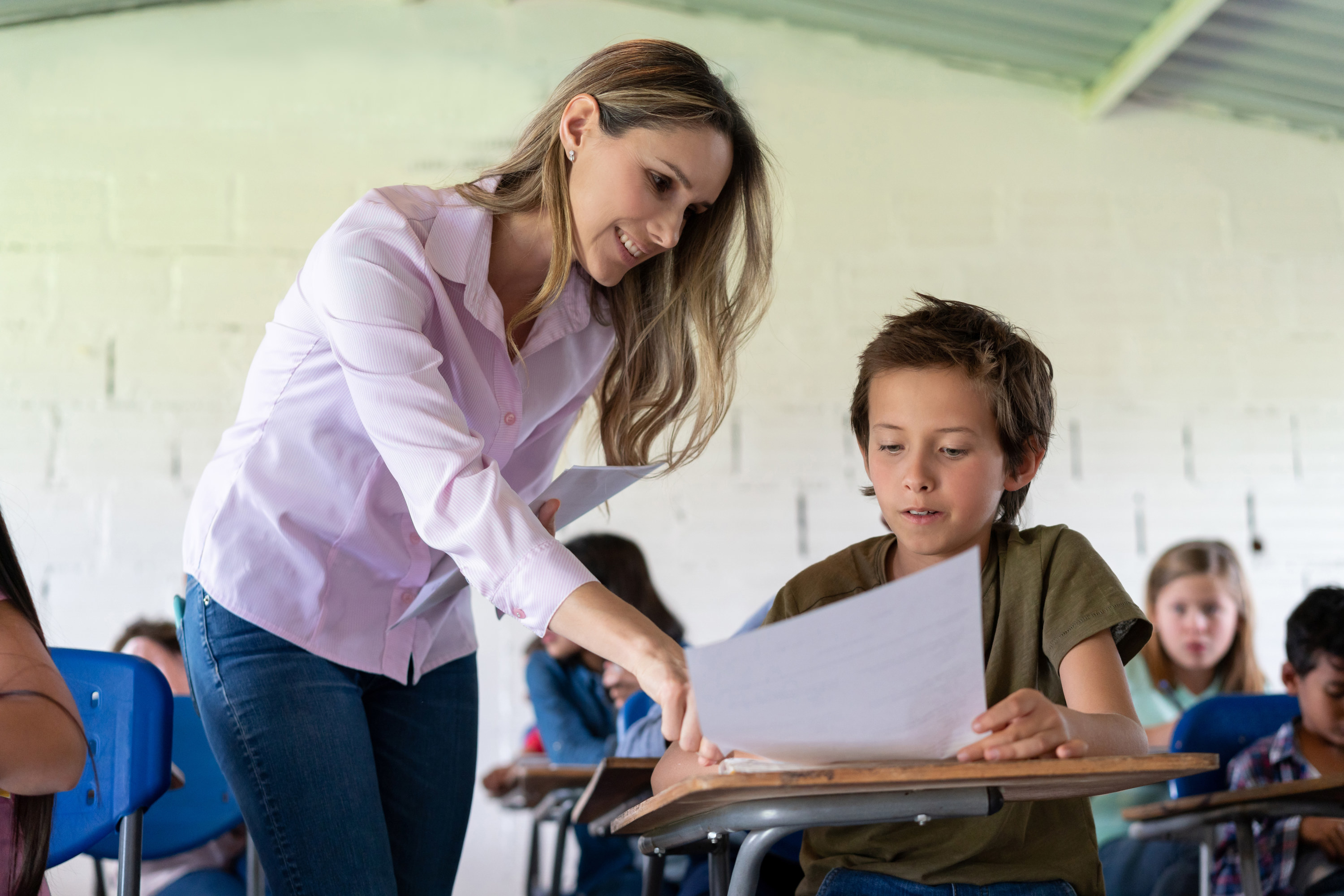 A teacher helps one of her students with an assignment during class