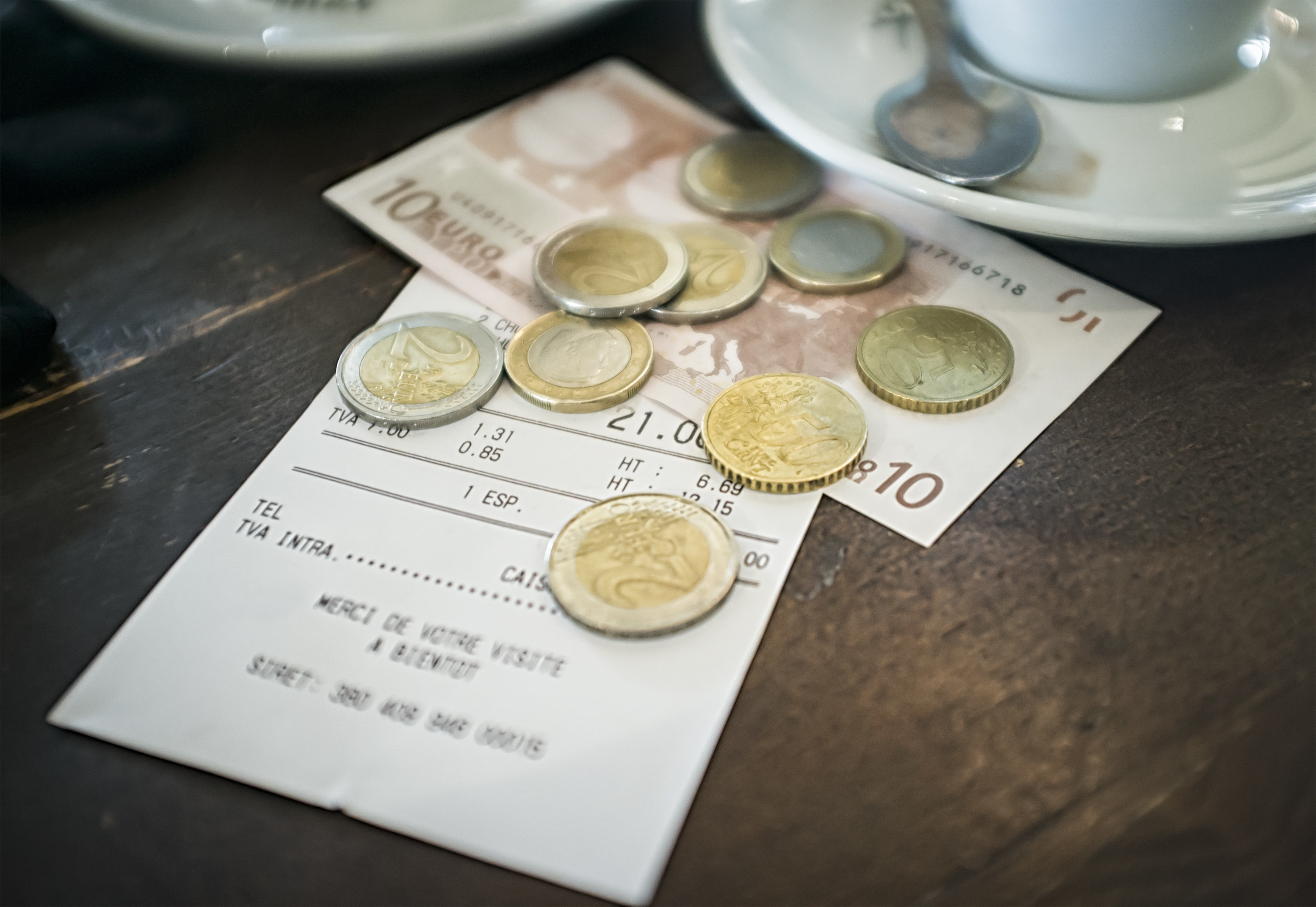 A bill with payment in euros on the table of a cafe