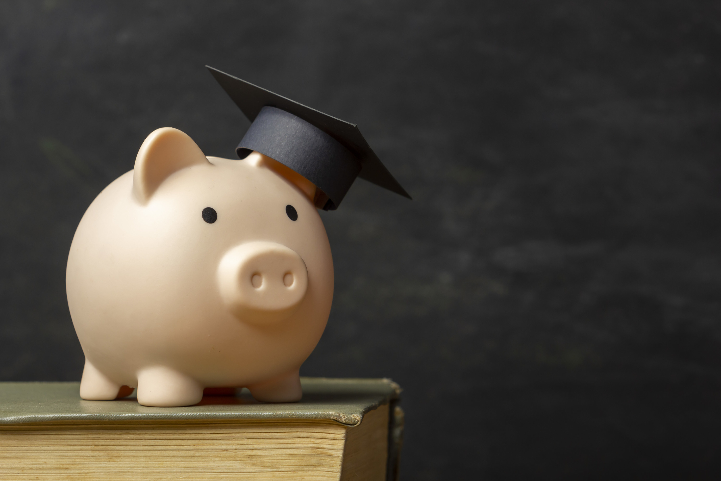 A piggy bank with a graduation cap on