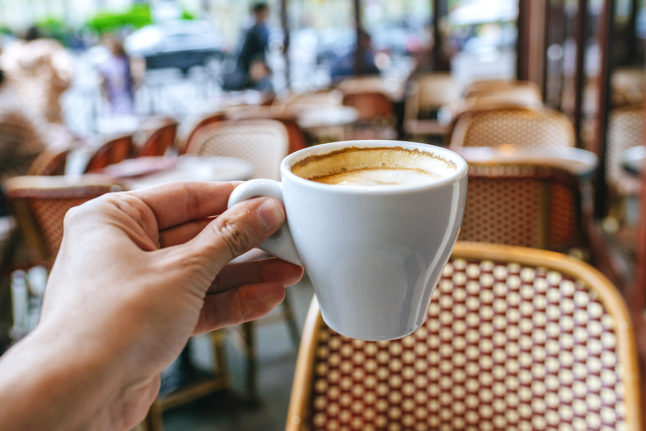 Close-up of man&#x27;s hand with coffee cup in Paris bar