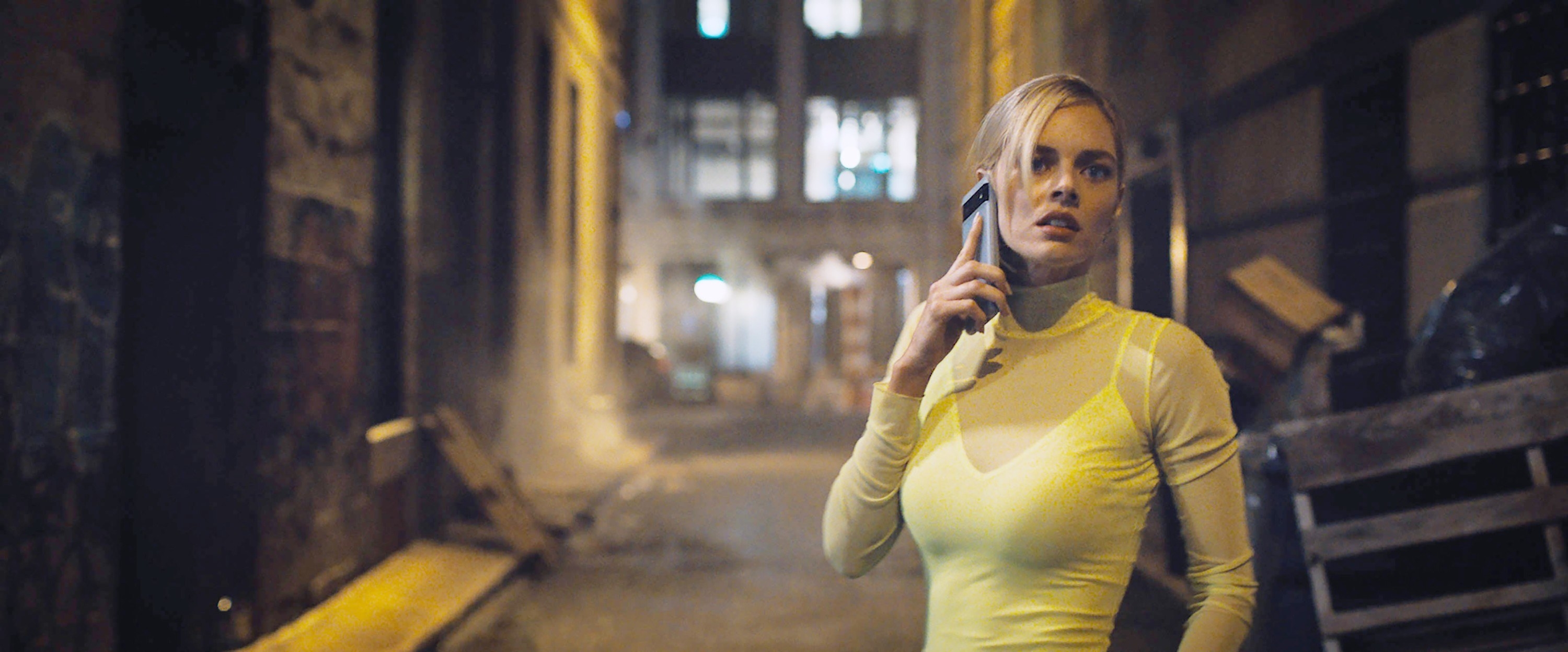 Samara Weaving answers a phone call in an alley