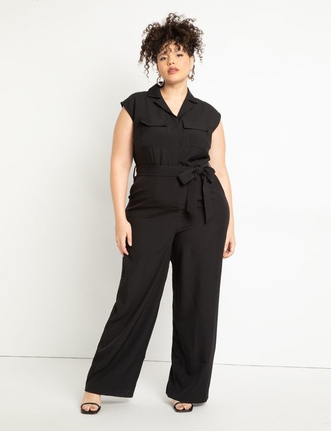 Model wearing black jumpsuit with black shoes