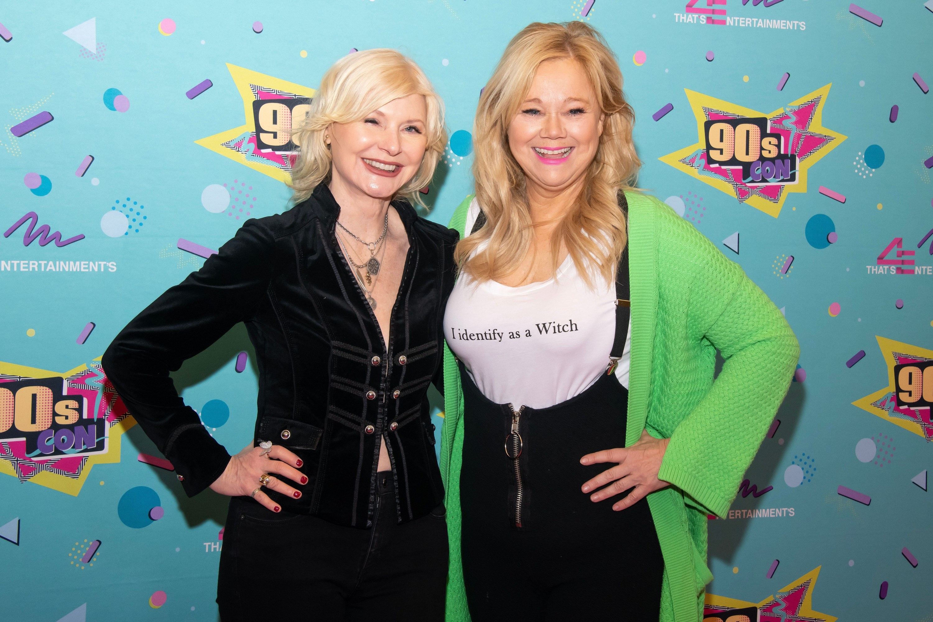 Beth Broderick on the left and Caroline Rhea on the right as the pose on the red carpet. Caroline is wearing a t-shirt that says, &quot;I identify as a Witch&quot;