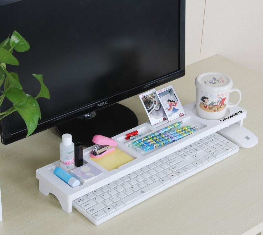 the desk organizer filled with office supplies perched over a keyboard