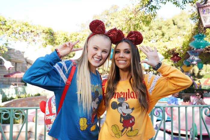 JoJo posing with another person for a photo at Disneyland. They&#x27;re both wearing sequined Minnie Mouse ears
