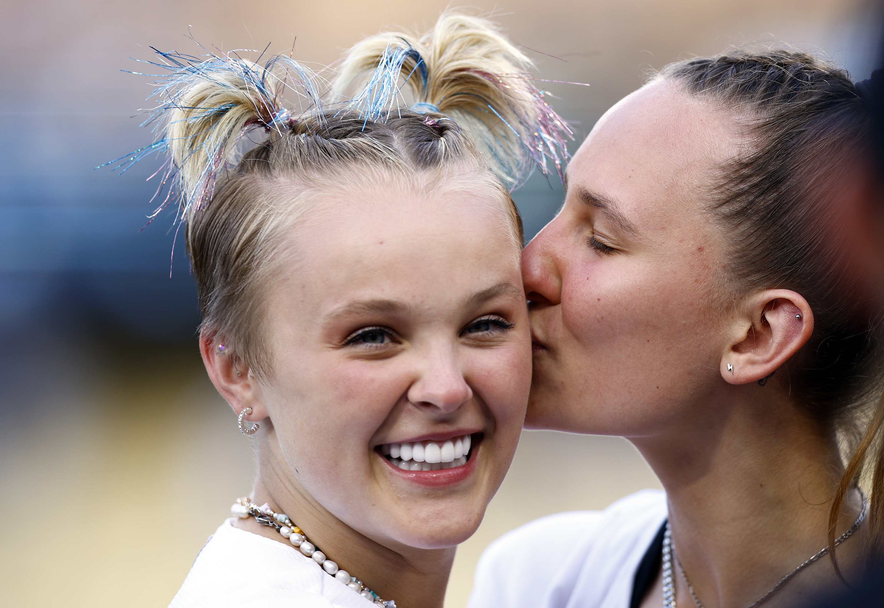 Kylie kissing JoJo on the cheek at a baseball game