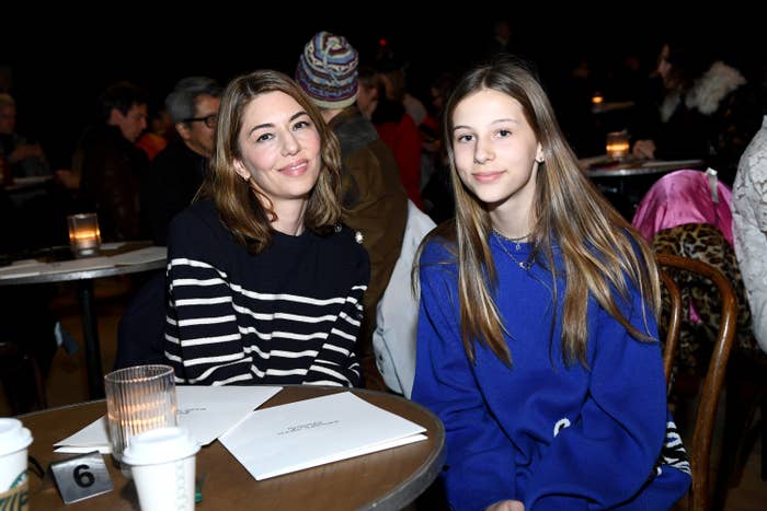 Romy sits with her mom at an event