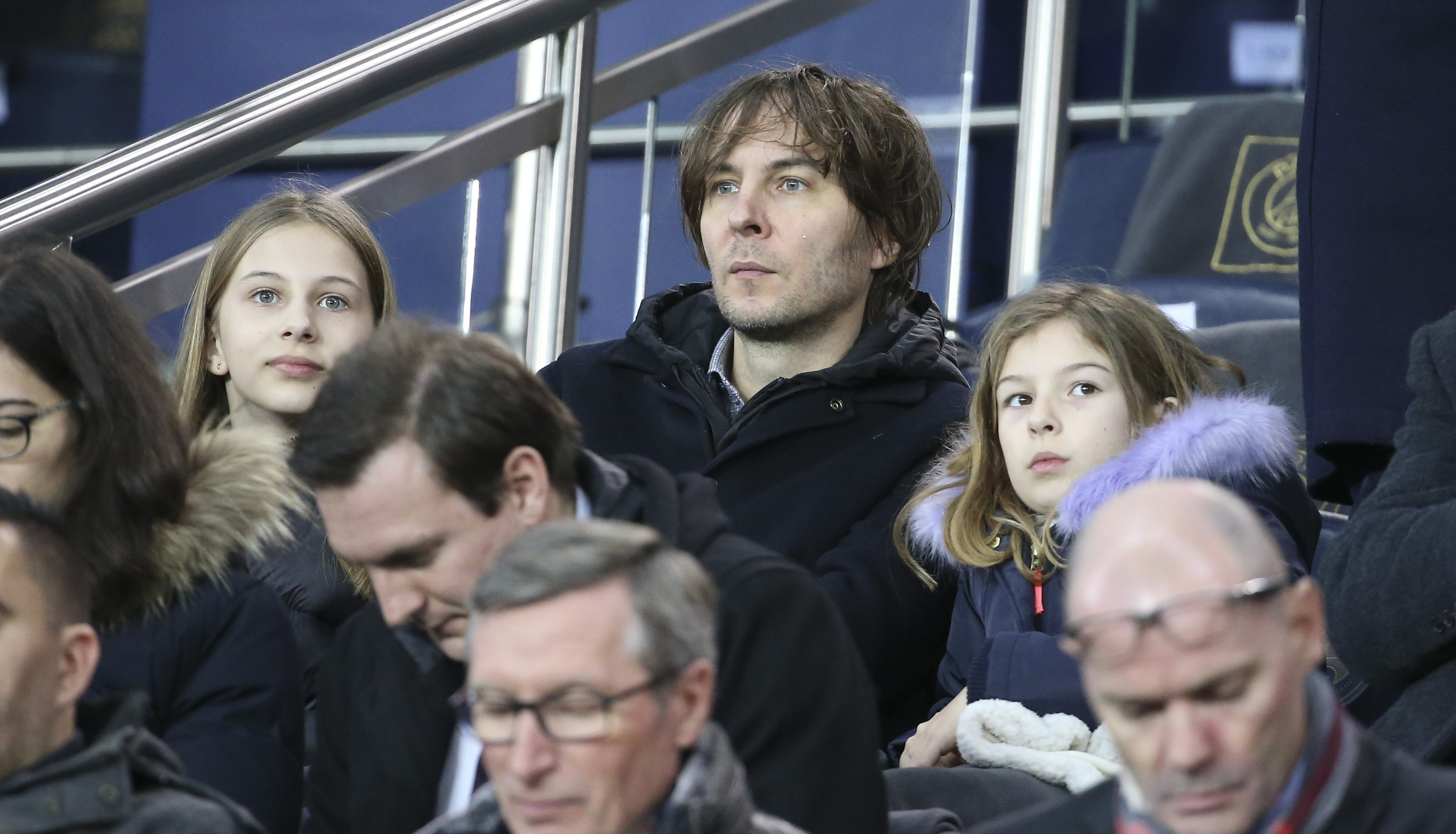 Romy sits next to her father at an event