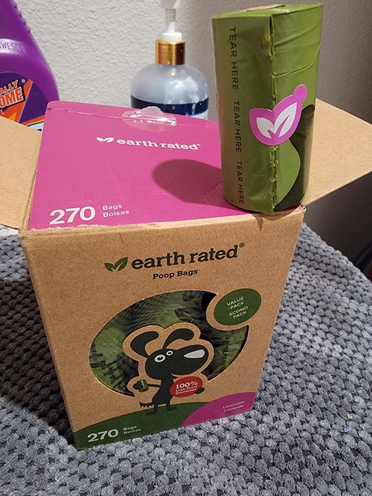 Green roll of waste bags sitting on top of cardboard packaging box