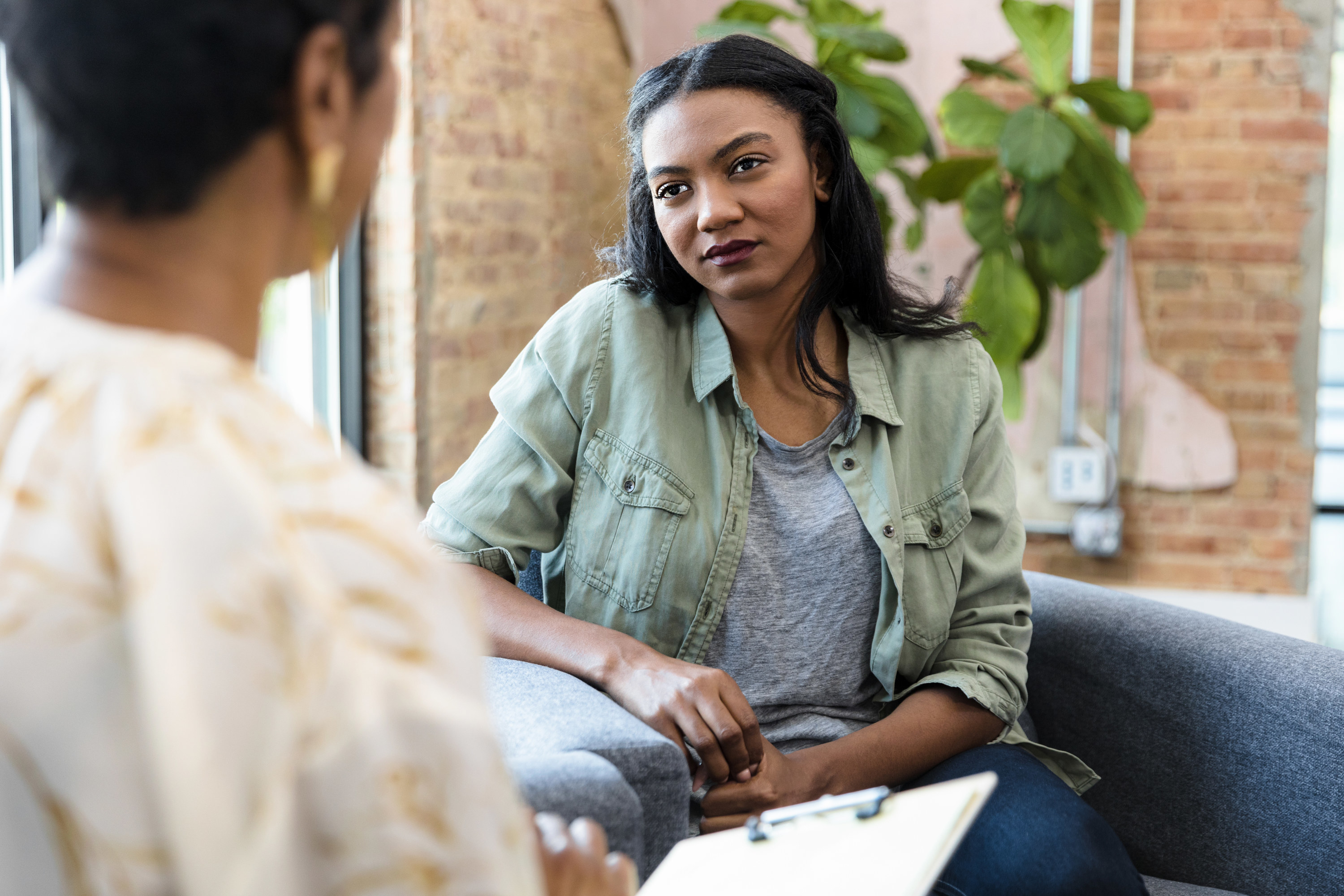 A girl listens to a therapist as the two sit for a session