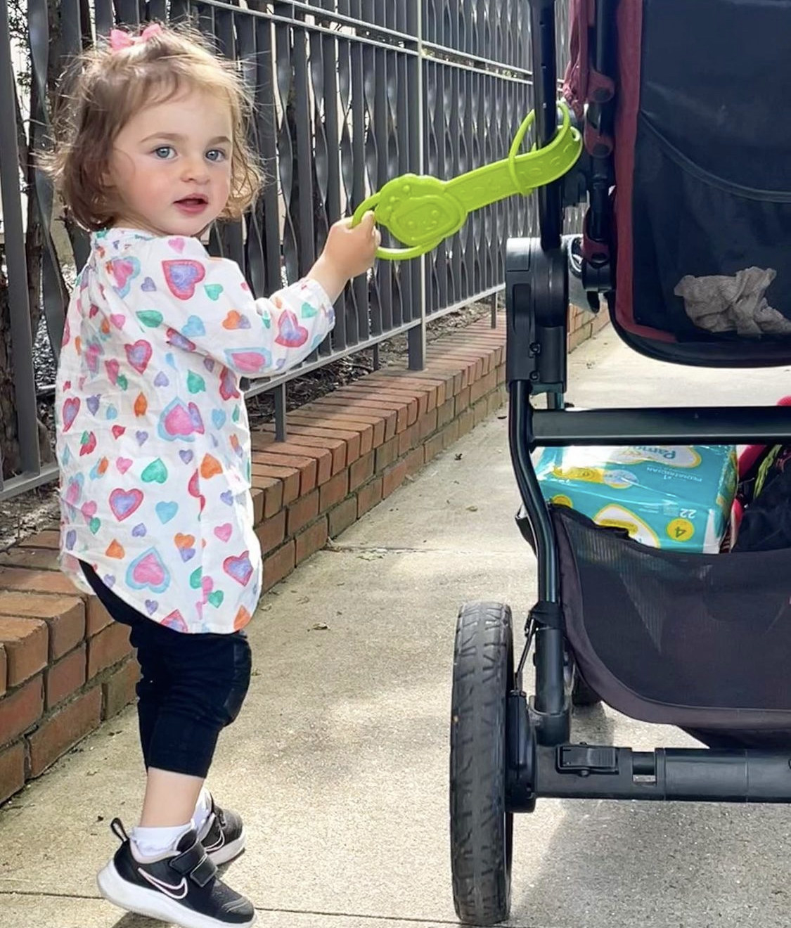 Toddler holding handle on stroller