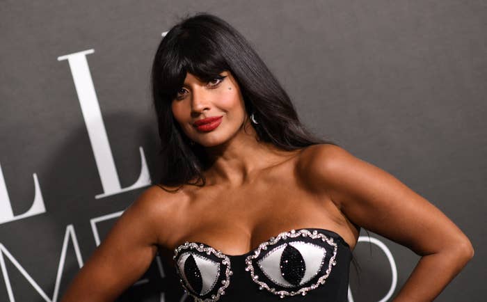 A closeup of Jameela on the red carpet wearing a strapless outfit that has two eyes covering her bust