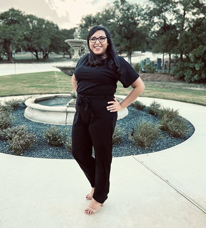 reviewer posing in the black romper in front of fountain