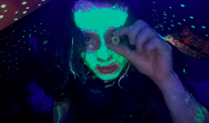 A young girl wears neon face paint