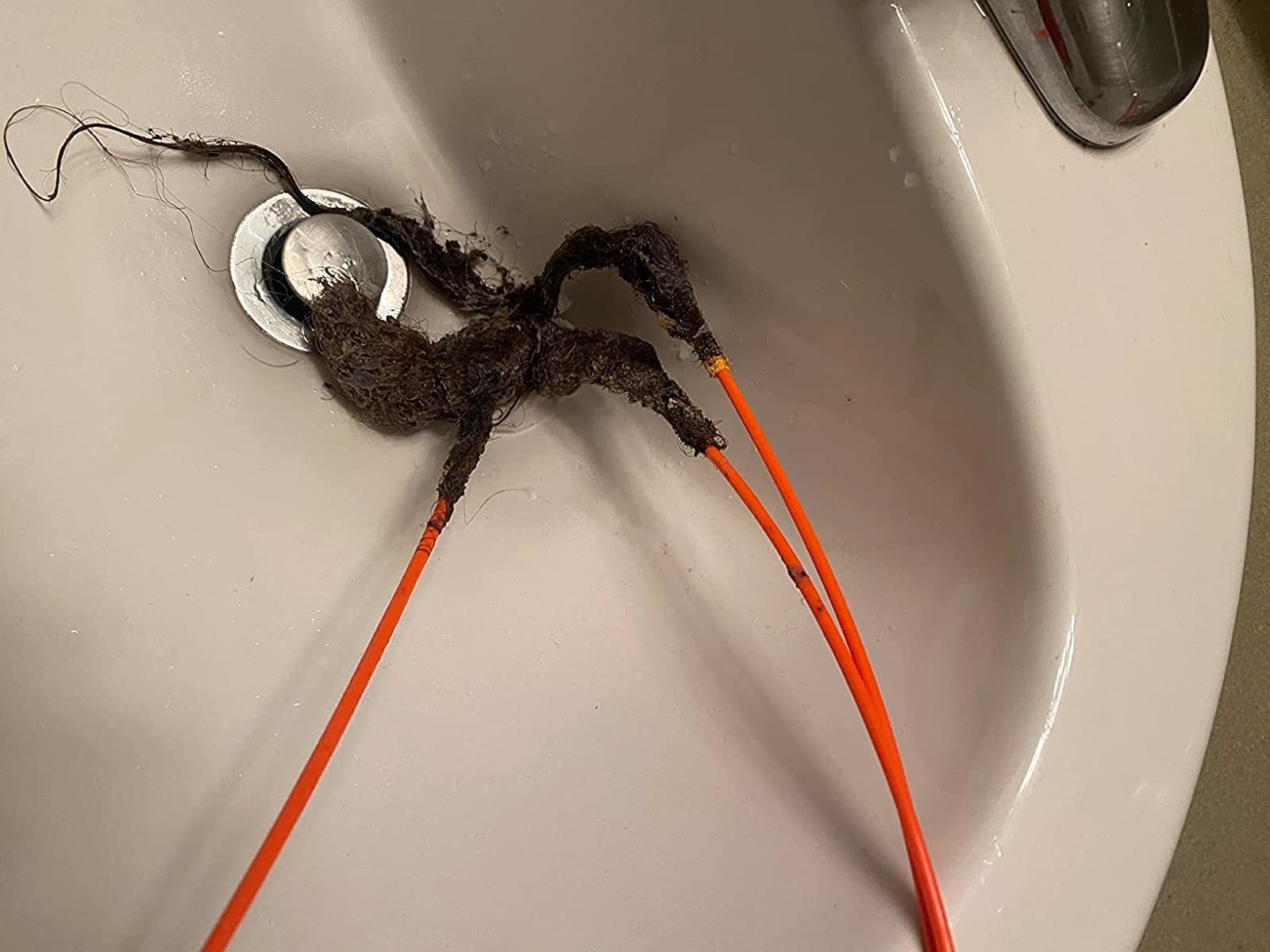 Reviewer&#x27;s photo of the Drain Weasel with all the gunk it yanked out of a sink on it