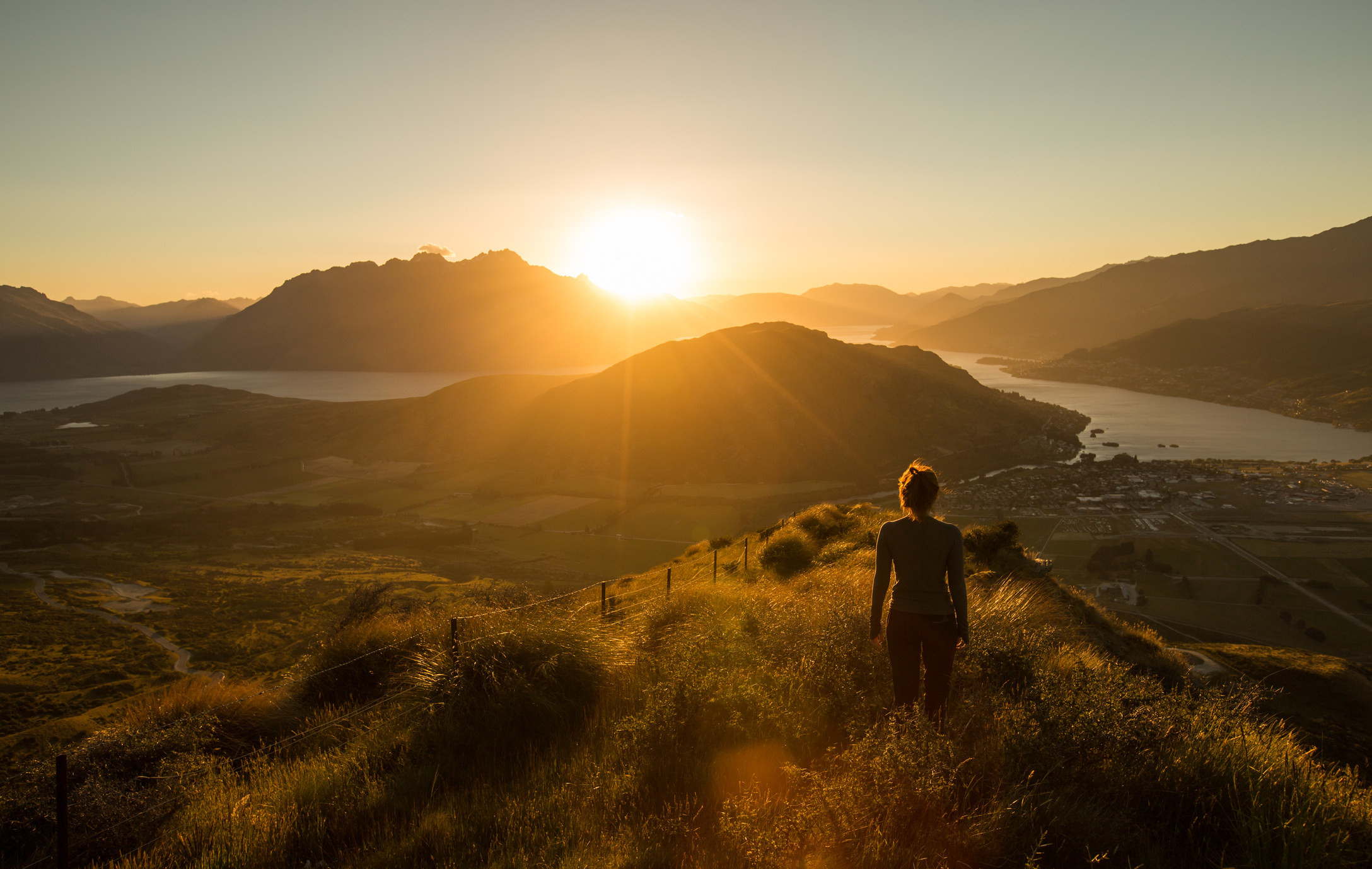 A woman&#x27;s silhouette at sunset on a mountain.