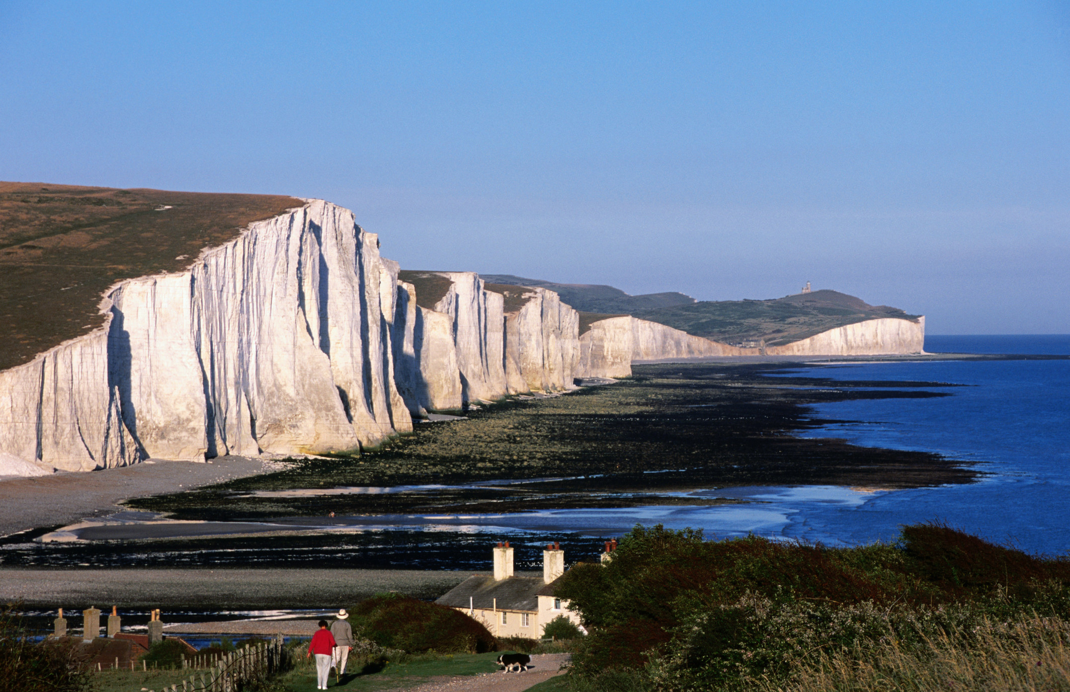 People walking towards cliffs in the UK.