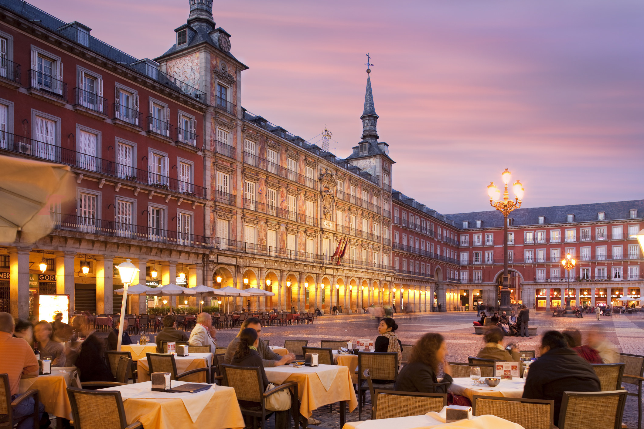 People sitting outdoors in a plaza in Madrid.