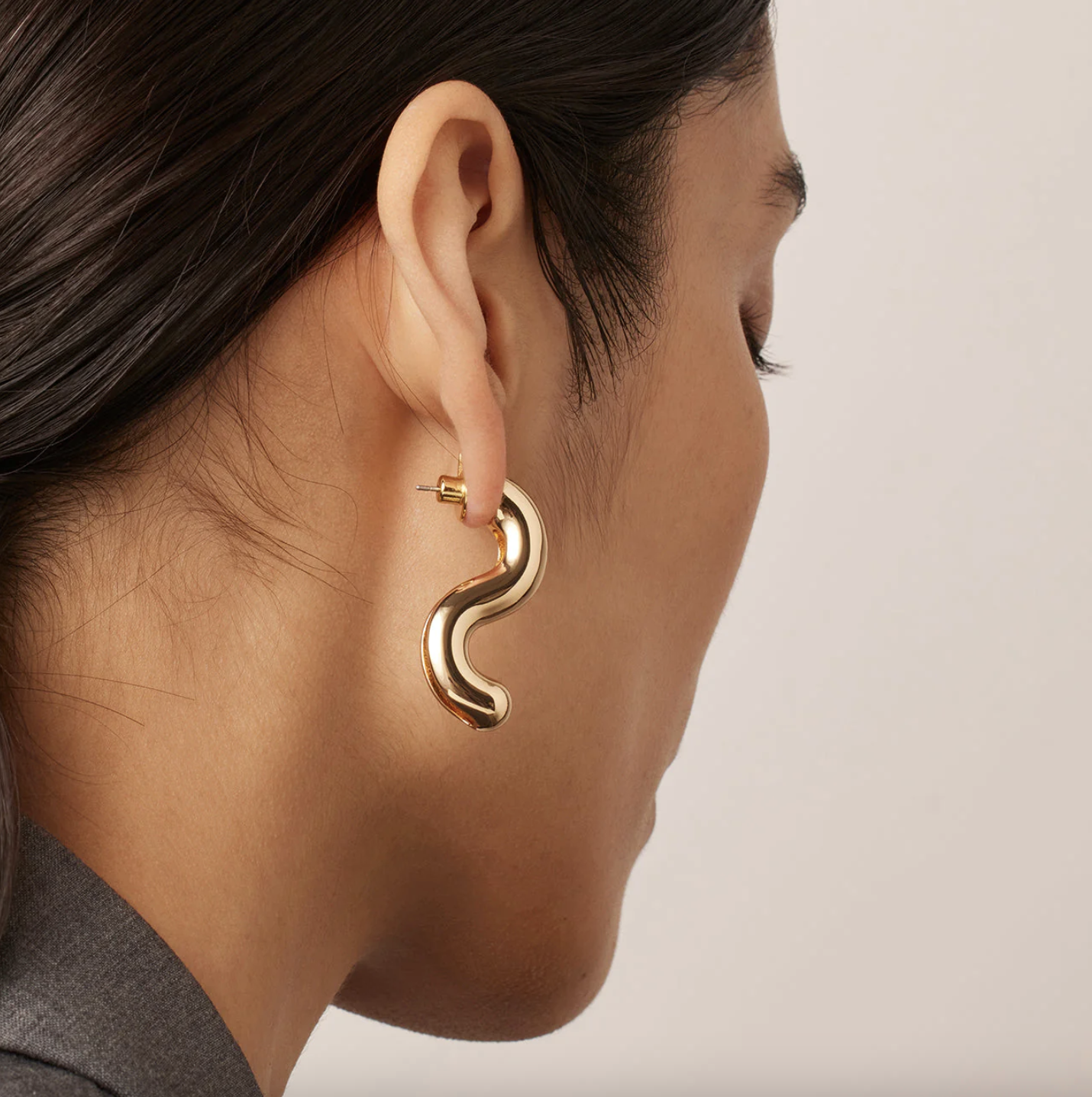 a person wearing the squiggly earrings