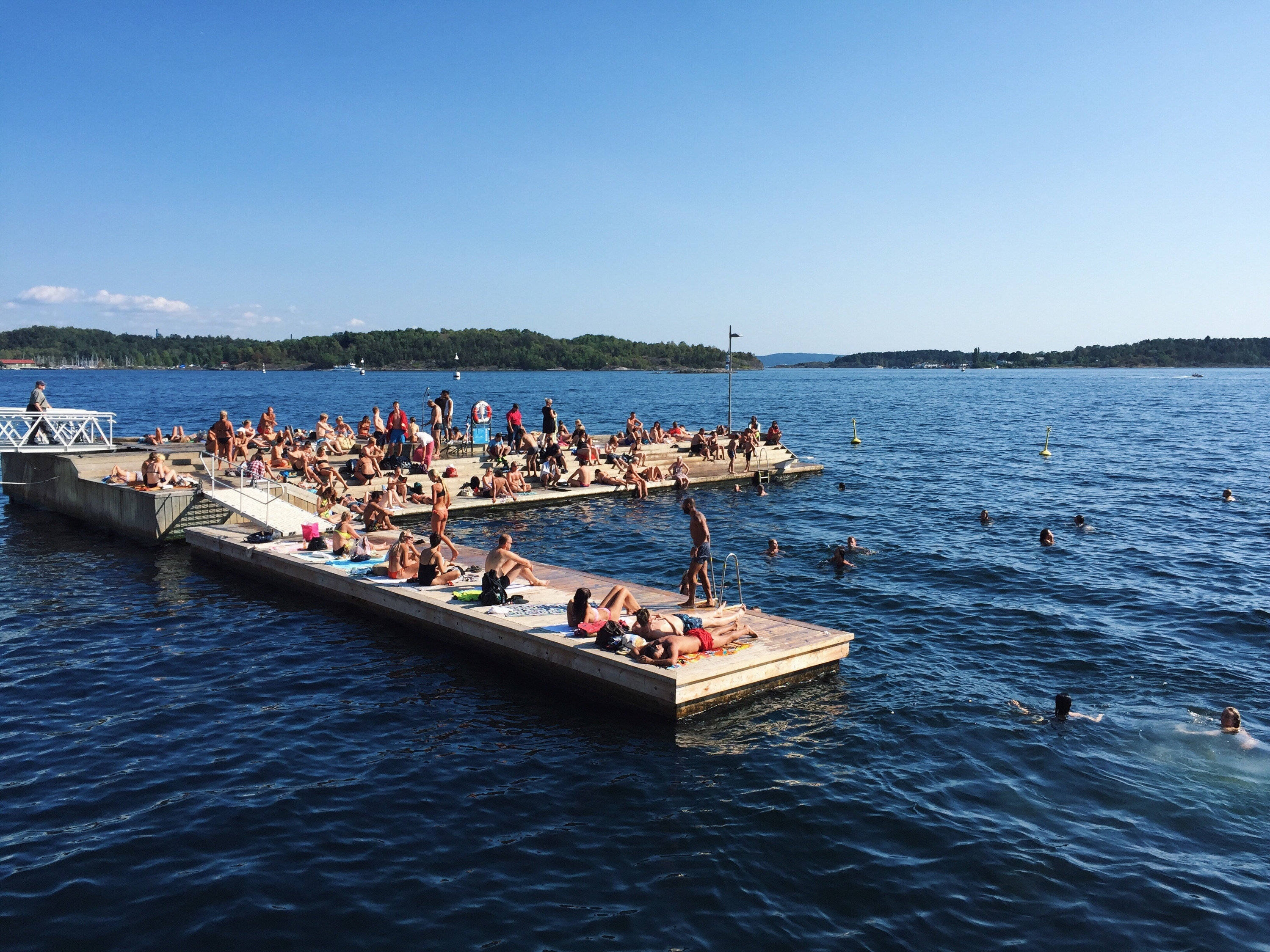 People sitting on a pier in the sea.