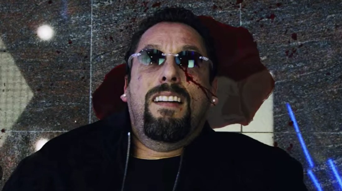 Adam Sandler as Howard in &#x27;Uncut Gems&#x27; lies on the ground with blood pooling around his head