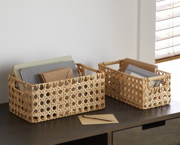 a two-piece wicker basket set holding letters on a desk