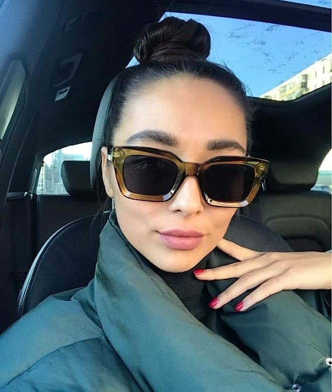 a person wearing the sunglasses while taking a selfie in a car