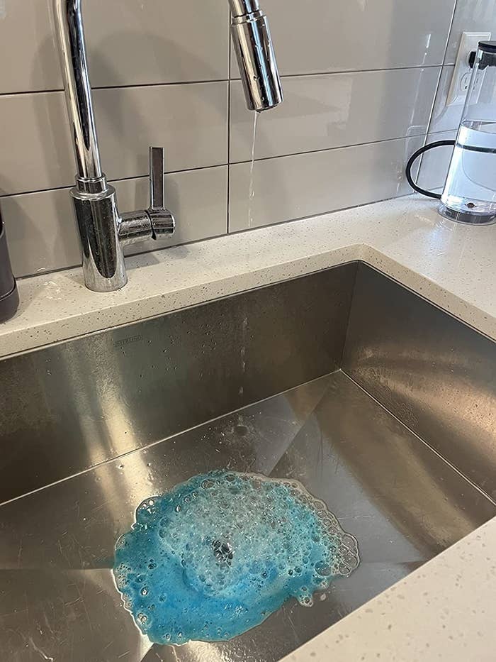 Reviewer image of blue foam in their stainless steel sink