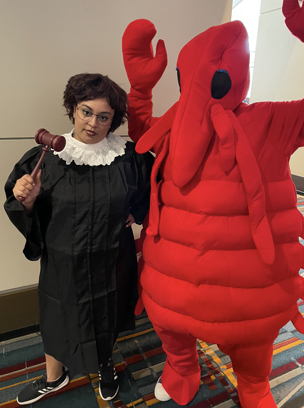Woman in judge costume stands with woman in lobster costume