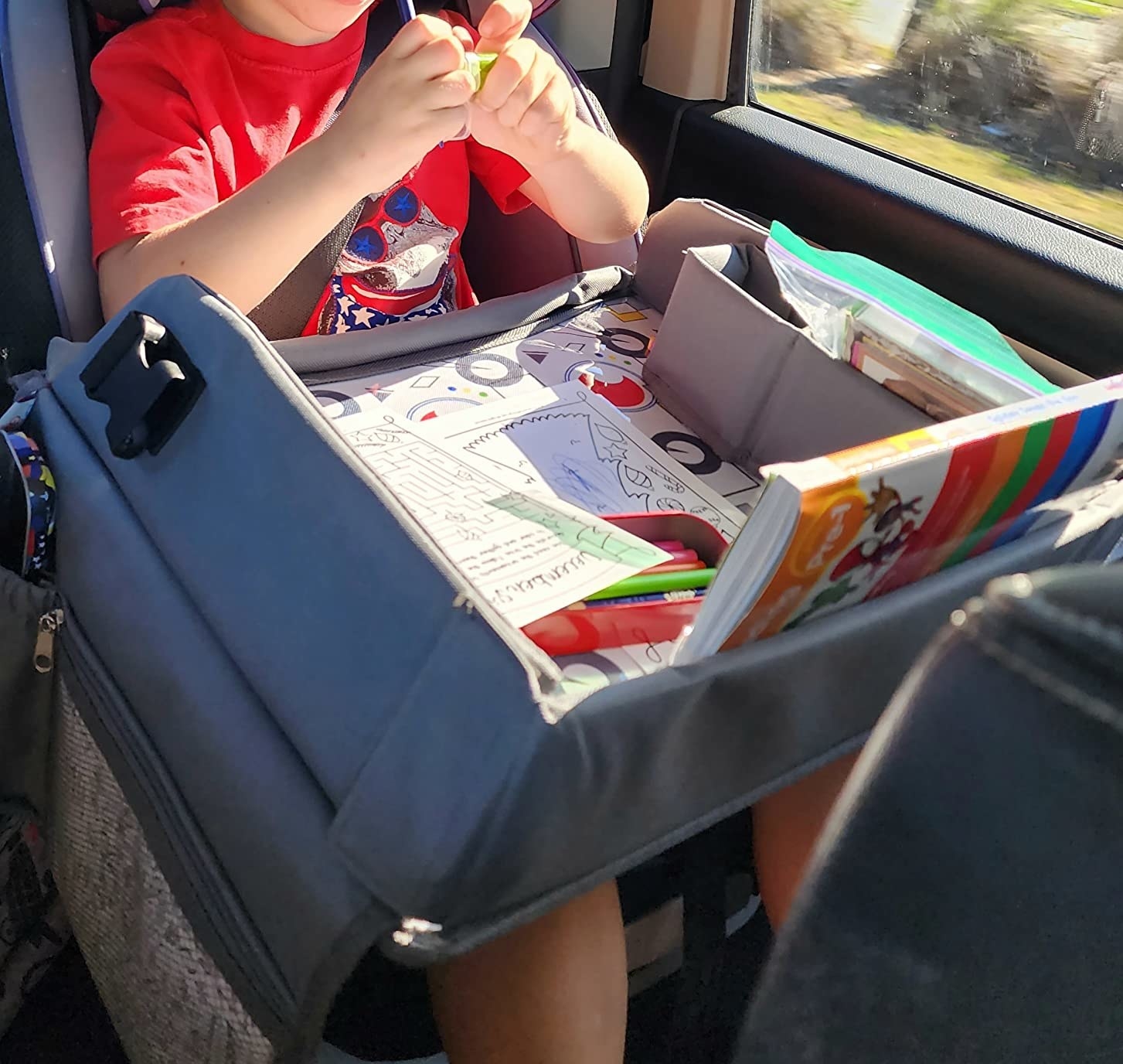 Kid using activity tray in car