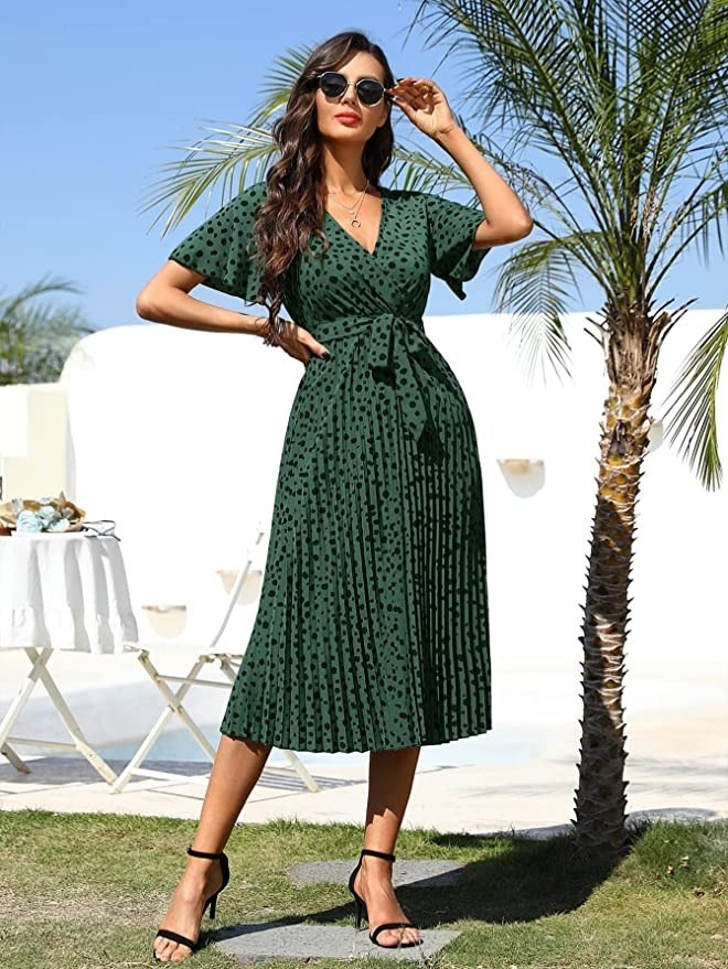 a model wearing the green and black dotted dress