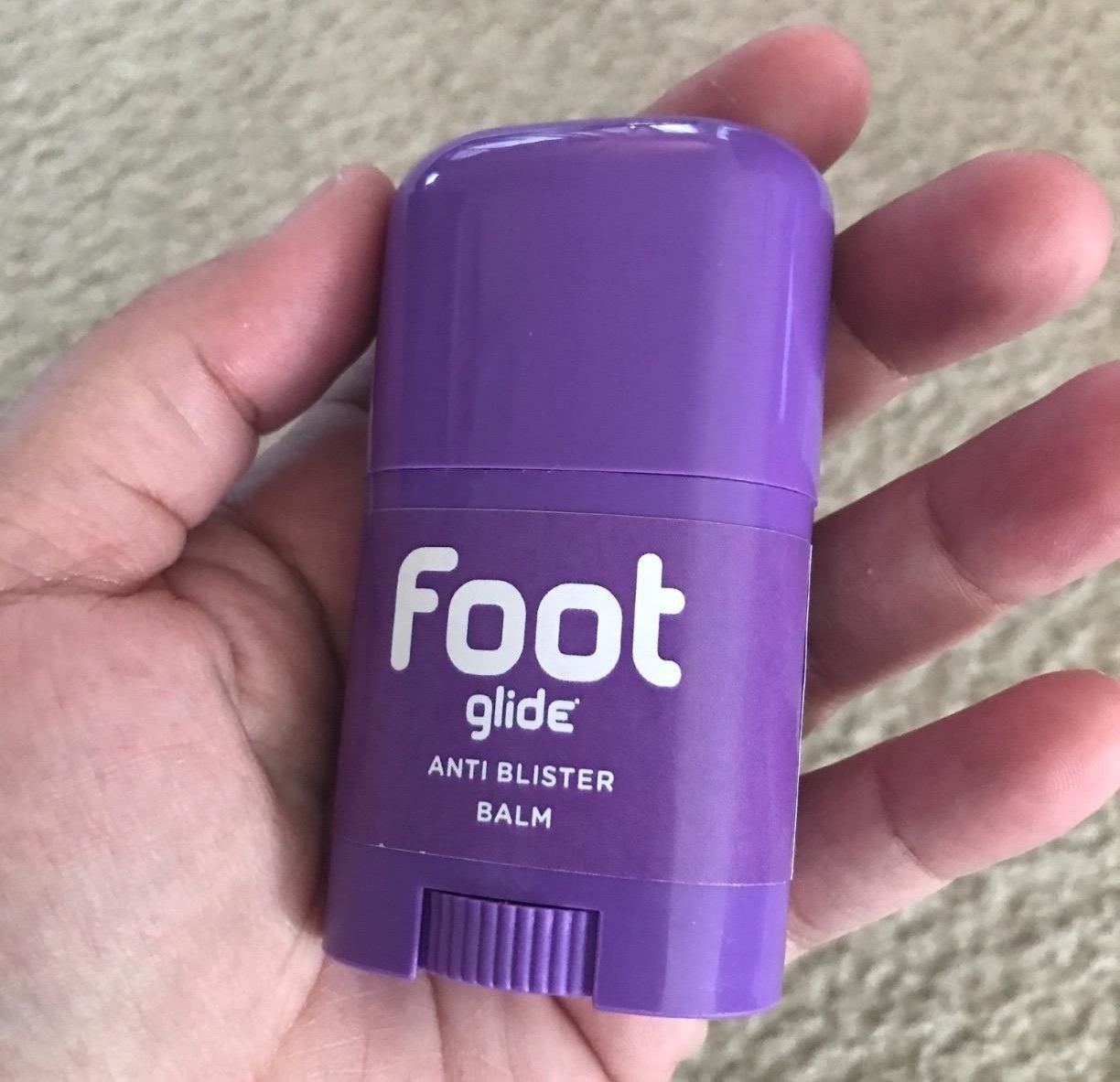 reviewer holding the small purple balm in their hand
