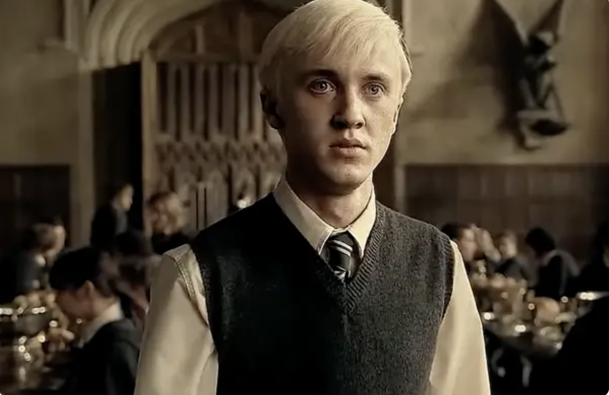 Close-up of Tom as Draco in a shirt, vest, and tie