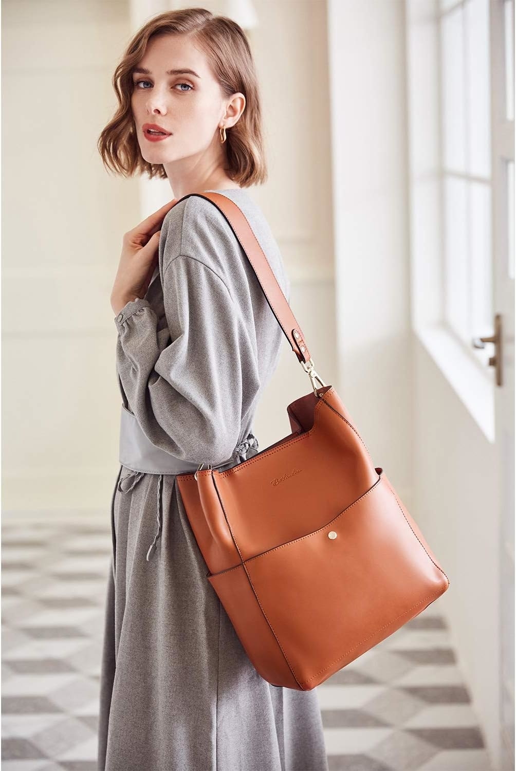 a person wearing the leather tote over their shoulder