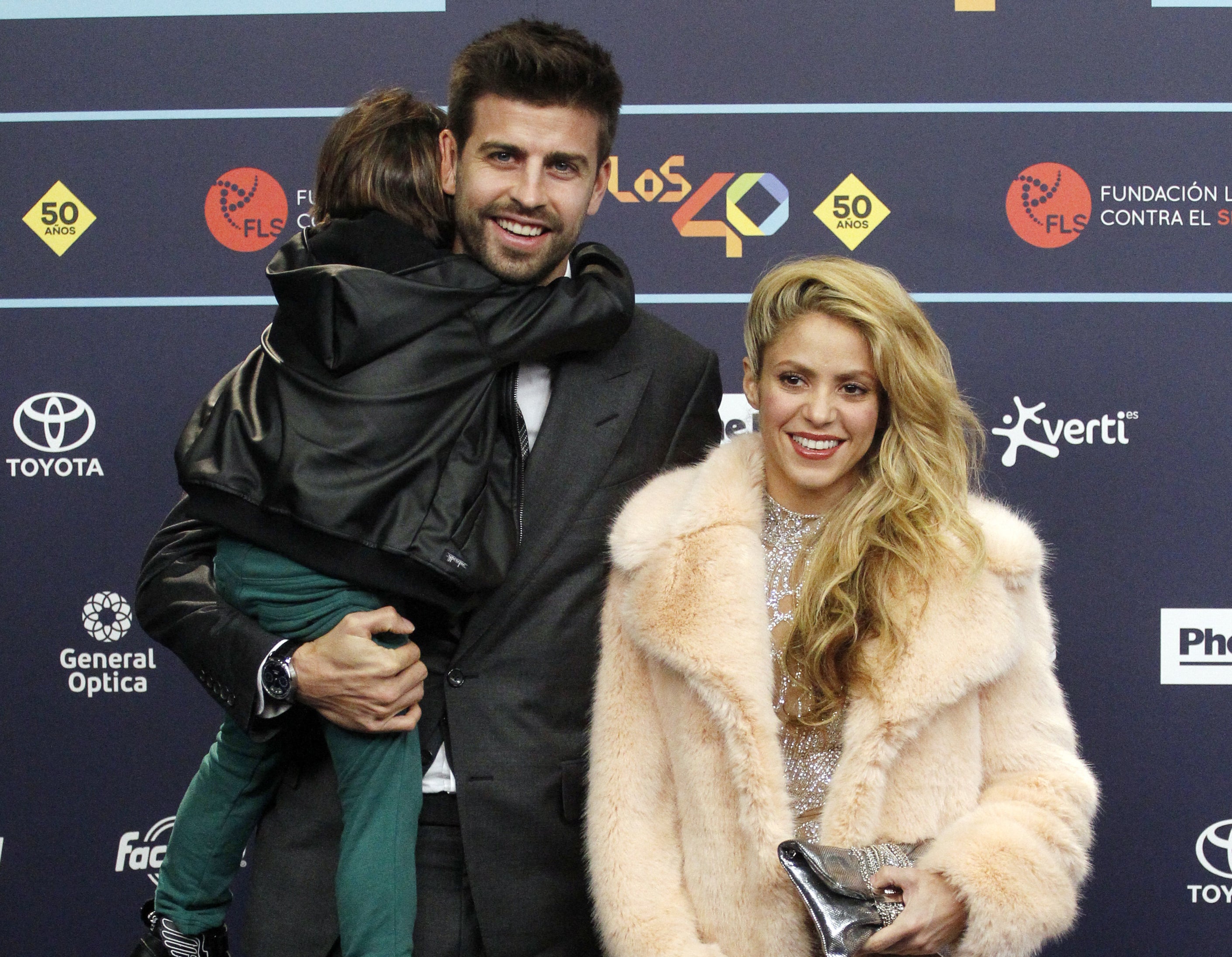 A closeup of Shakira and Gerard and one of their sons