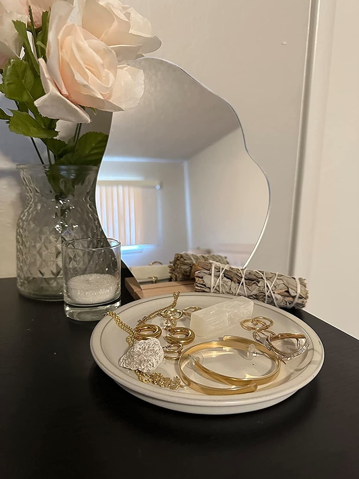 Reviewer&#x27;s mirror on vanity table with tray of jewelry in front