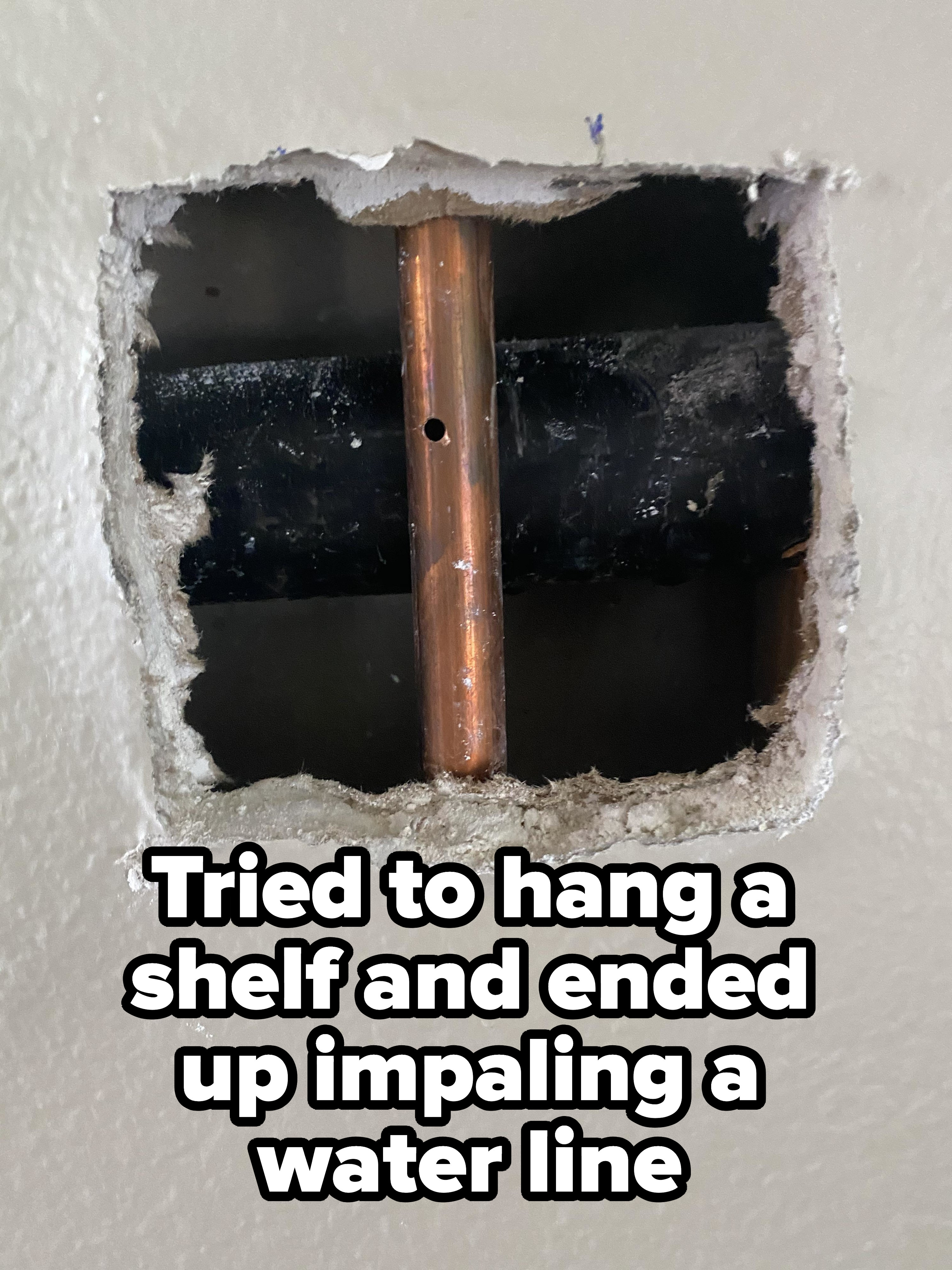 A hole in the wall exposing a pipe