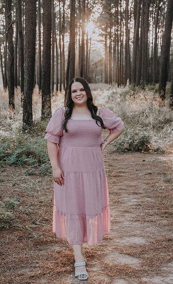 Reviewer wearing the pink ruffled dress in a forest