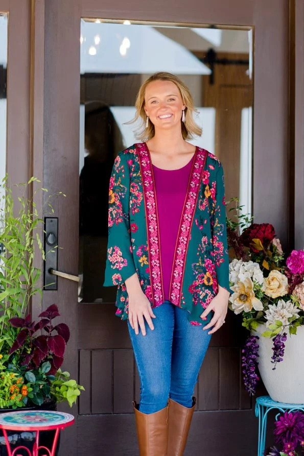a model wearing the fuschia and teal floral duster