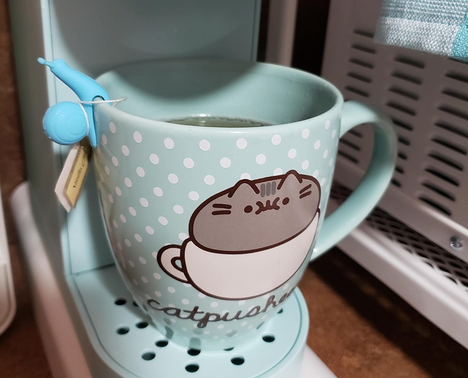 Reviewer image of blue snail holding a teabag in their mug