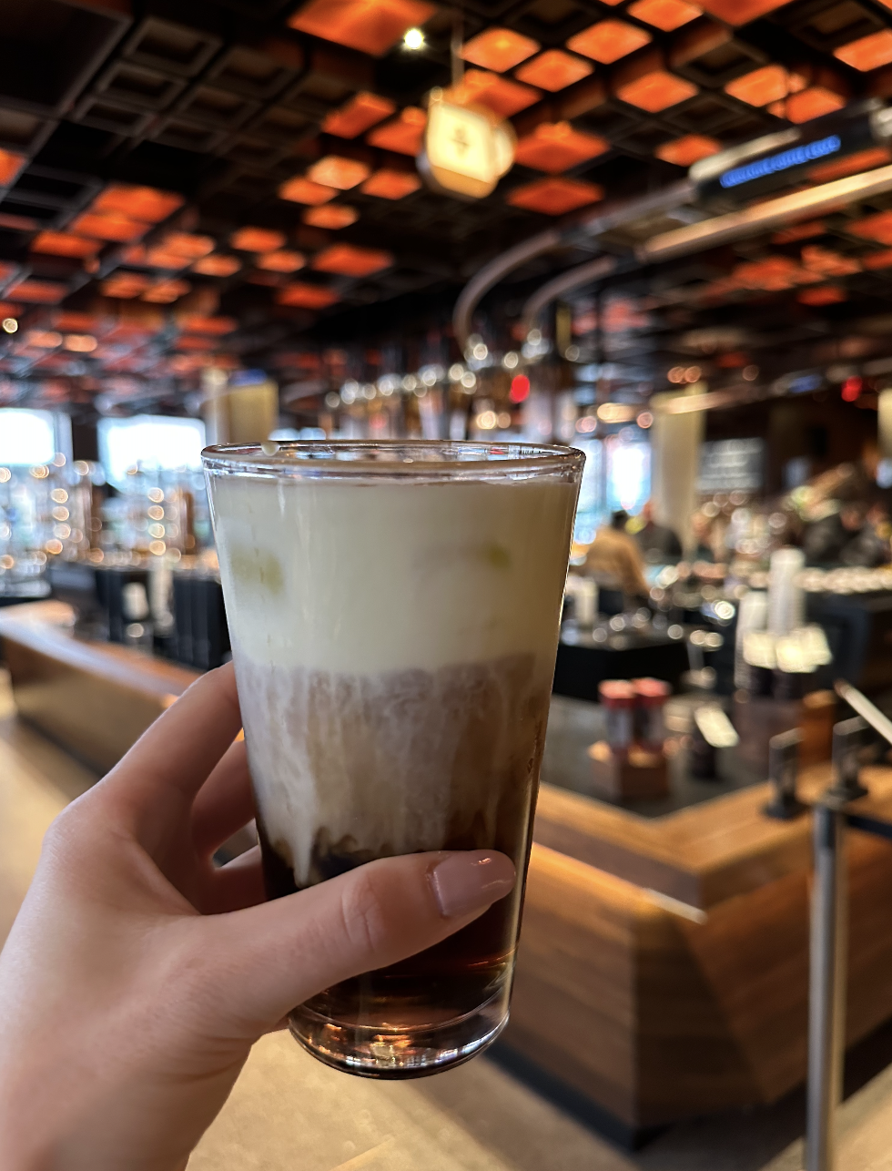 a hand holding a cold brew coffee