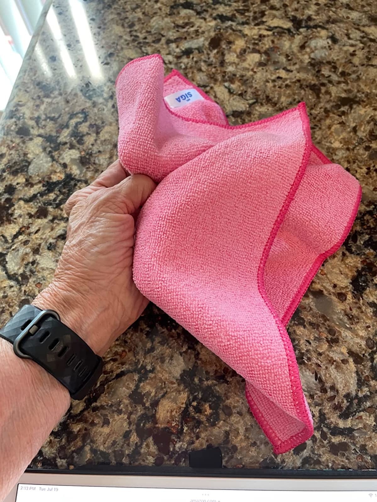 Reviewer holding pink microfiber cloth