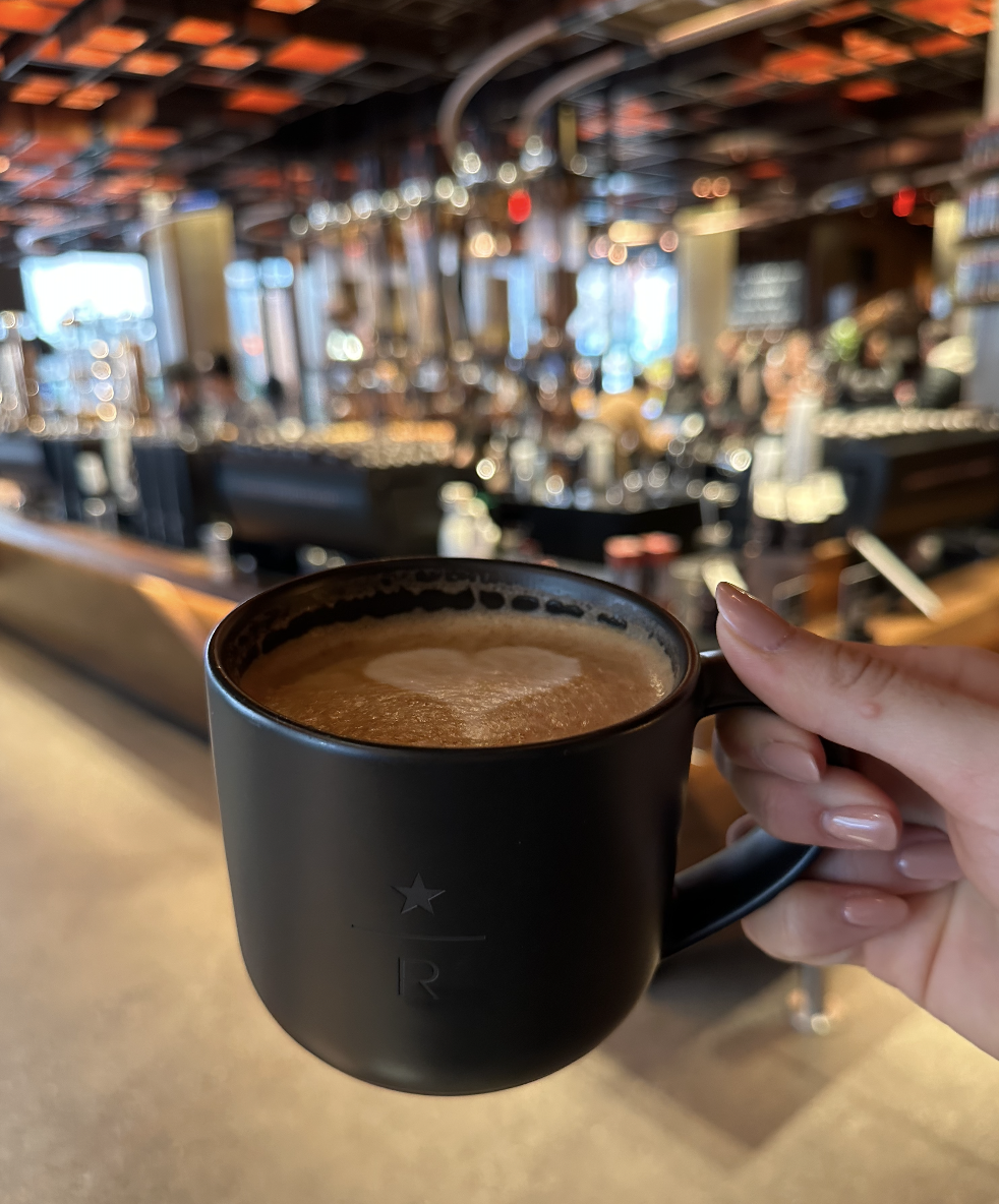 a hand holding a latte in a mug