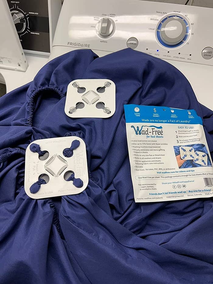 Washer with a blue garment and instructions for a wrinkle-removing product displayed on top