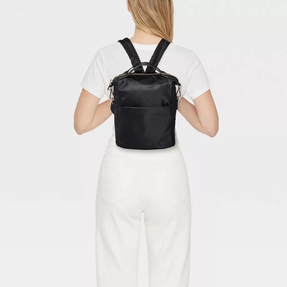 Model wearing black mini backpack