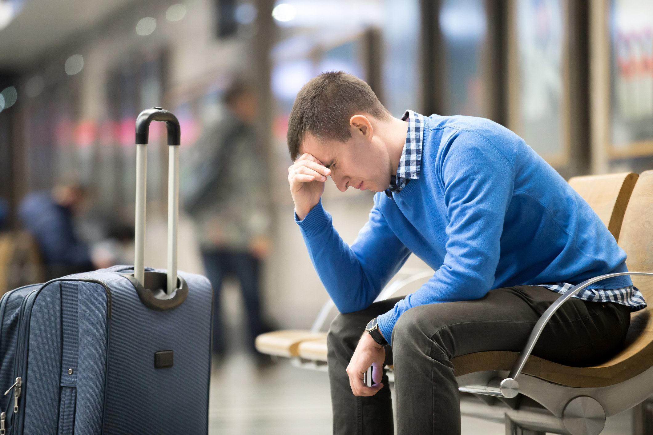 A man looking stressed in an airport
